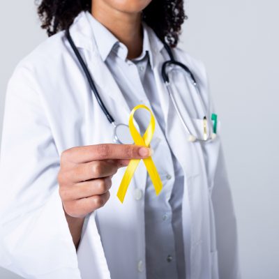Doctor holding yellow sarcoma ribbon.